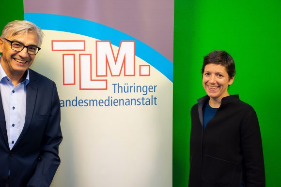 Ein Mann und eine Frau stehen vor einem TLM Banner und lächeln in die Kamera40 Foto