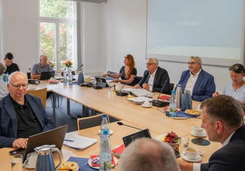 Viele Menschen sitzen in einem Versammlungsraum