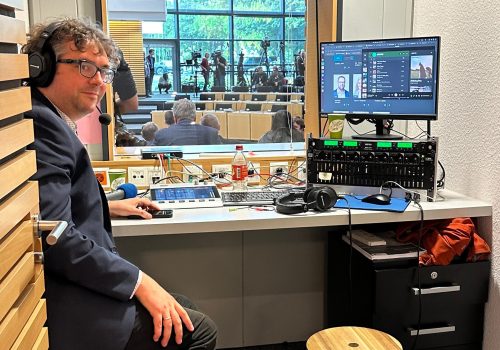 Ein Mann schaut aus einem kleinen Rundfunkstudio heraus.