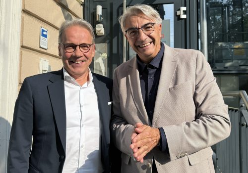 Zwei Männer lächeln in die Kamera