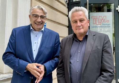 Zwei Männer lächeln in die Kamera