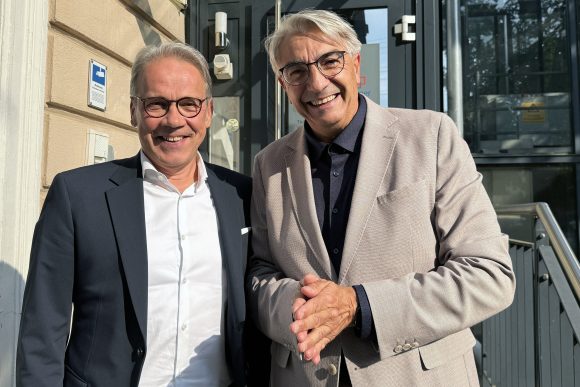 Zwei Männer lächeln in die Kamera