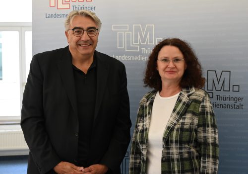Ein Mann und eine Frau stehen nebeneinander und schauen freundlich in die Kamera.