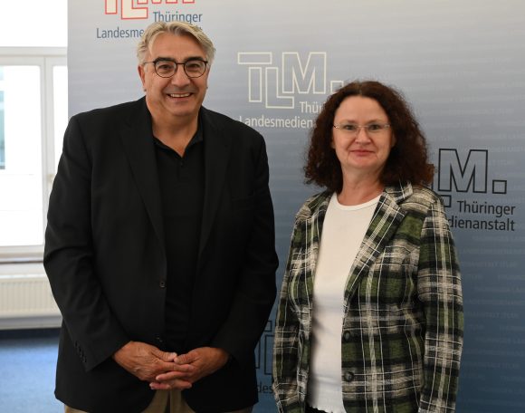 Ein Mann und eine Frau stehen nebeneinander und schauen freundlich in die Kamera.
