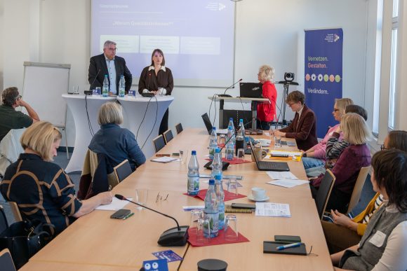 Foto (TLM): Eine Frau und ein Mann referieren vor Zuhörenden