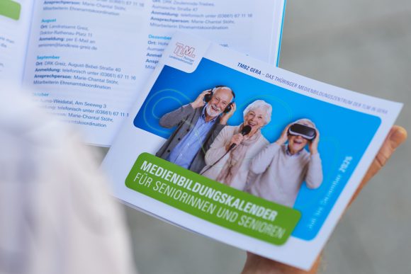 Coverfoto mit drei älteren Personen auf aufgeklappter Broschüre